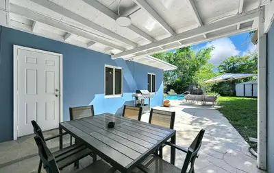 a patio with a wooden table and chairs at The Perfect South Florida Experience in Fort Lauderdale