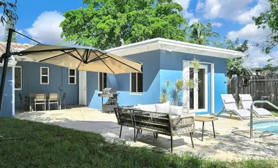 a blue house with a patio and an umbrella at The Perfect South Florida Experience in Fort Lauderdale