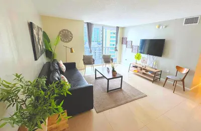 a living room with a couch and a tv at Bright & Modern Condo in Brickell w Pool Access in Miami