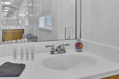 a white bathroom with a sink and a mirror at Stunning Tropical Getaway Steps To The Beach with Pool in Hollywood