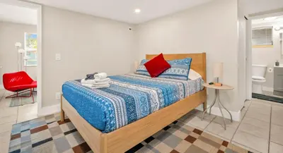 a bedroom with a bed and a red chair at The Jute Box - Pool - Waterview - Wilton Drive in Fort Lauderdale