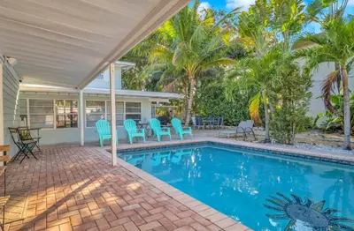 a swimming pool with blue chairs and palm trees at The Jute Box - Pool - Waterview - Wilton Drive in Fort Lauderdale
