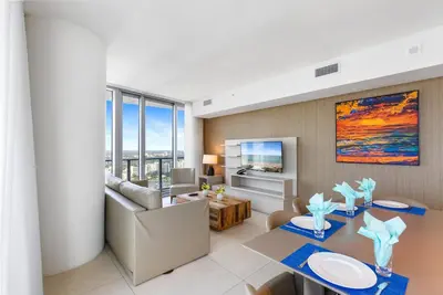 a living room with a dining table and a couch at Corner Penthouse Ocean and City View in Hollywood