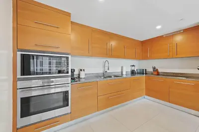 a kitchen with wooden cabinets and stainless steel appliances at Luxury Waterfront Brickell ICON W-Hotel Balcony Water Views in Miami