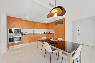a kitchen with wooden cabinets and a table and chairs at Luxury Waterfront Brickell ICON W-Hotel Balcony Water Views in Miami
