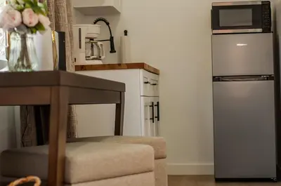 a kitchen with a refrigerator and a chair with flowers at Comfy and Relaxed in Cutler Bay