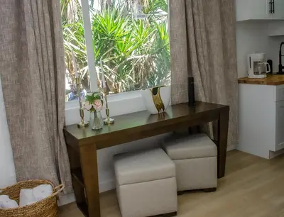 a table with flowers and a window in a kitchen at Comfy and Relaxed in Cutler Bay
