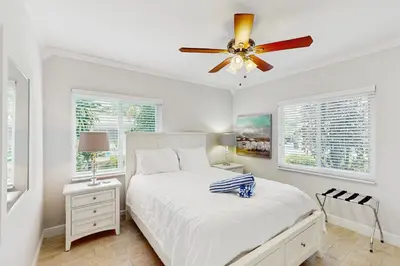 a white bedroom with a bed and a ceiling fan at The Front House & Cottage in Fort Lauderdale