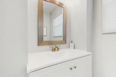a white bathroom with a sink and a mirror at The Front House & Cottage in Fort Lauderdale