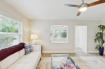 a living room with a white couch and a ceiling fan at The Cottage in Fort Lauderdale