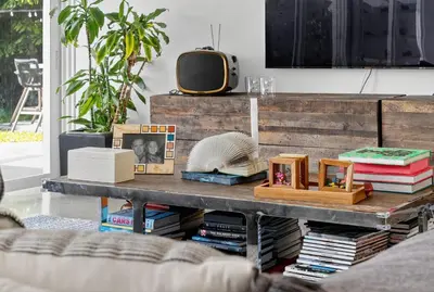 a living room with a coffee table with books at Isla Solana by Rove Travel - Waterfront with Pool in Miami