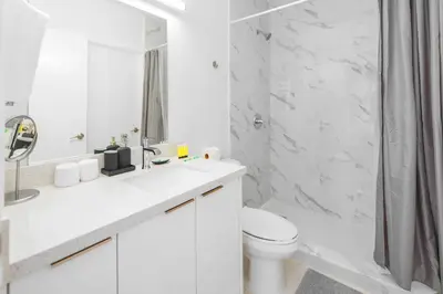 a white bathroom with a toilet and a shower at Wynwood Retreat - Rooftop Pool & Neighborhood Views in Miami