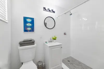a white bathroom with a toilet and a mirror at Modern Studio Retreat to Explore Miami in Miami