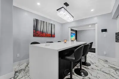 a kitchen with a white counter and black chairs at RJ Home Away From Home LLC in Miami Gardens