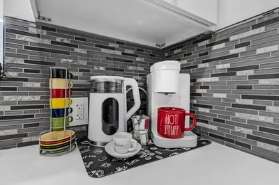 a kitchen counter with two coffee makers on a shelf at RJ Home Away From Home LLC in Miami Gardens