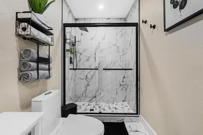a bathroom with a marble shower with a toilet at RJ Home Away From Home LLC in Miami Gardens