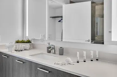 a white bathroom with a sink and a mirror at Waterline Corner Vies 2Br 2BA Suites in Miami