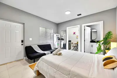 a bedroom with a large bed and a couch at Central Miami Studio - Wynwood 8 Min in Miami