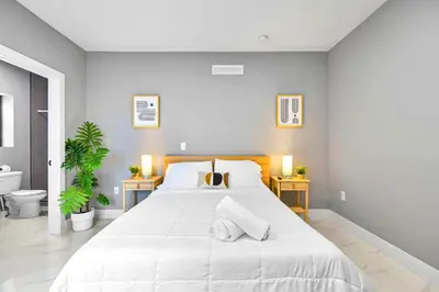 a bedroom with a large white bed with two night stands at Central Miami Studio - Wynwood 8 Min in Miami