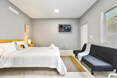 a bedroom with a large bed and a couch at Central Miami Studio - Wynwood 8 Min in Miami