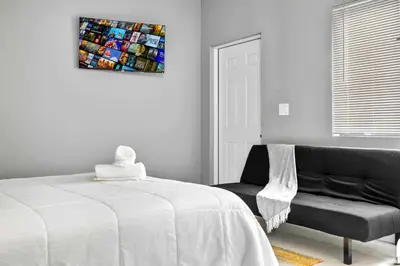 a bedroom with a bed and a couch and a painting at Central Miami Studio - Wynwood 8 Min in Miami