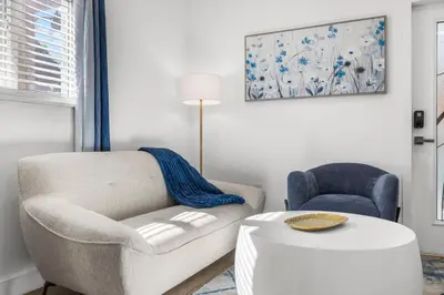 a living room with a couch and a chair and a table at Cozy By The Blue in Miami