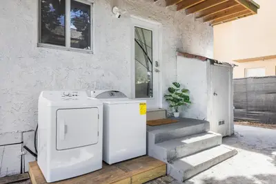 a kitchen with a refrigerator and stairs in front of a house at Cozy By The Blue in Miami
