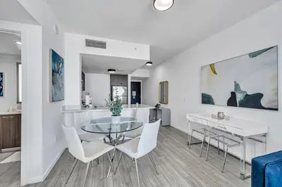 a dining room with a glass table and white chairs at Miami City Lights 2BR 2BA in Miami