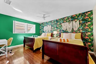 a bedroom with two beds and a green wall at Large 12 Guest Home w Pool, Hollywood FL in Hollywood