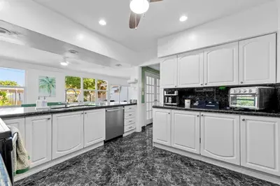 a large white kitchen with white cabinets and appliances at Large 12 Guest Home w Pool, Hollywood FL in Hollywood