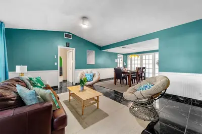 a living room with blue walls and leather furniture at Large 12 Guest Home w Pool, Hollywood FL in Hollywood