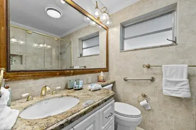 a bathroom with a sink and a toilet and a mirror at Large 12 Guest Home w Pool, Hollywood FL in Hollywood