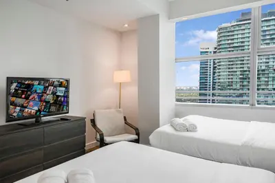 a bedroom with two beds and a flat screen tv at City View Condo in the Heart of Brickell in Miami