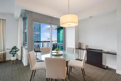 a kitchen and dining room with a glass table and chairs at City View Condo in the Heart of Brickell in Miami