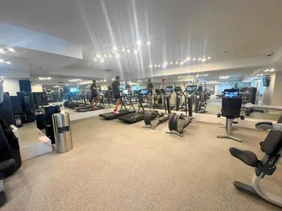 a gym with several people exercising on tread machines at City View Condo in the Heart of Brickell in Miami