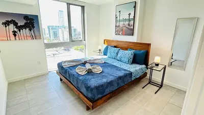 a bedroom with a bed with a blue comforter at Contemporary Comfort Rooftop Views & Full Kitchen in Miami