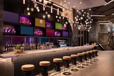 a bar with a row of stools in a restaurant at Skyline Studio Workspace & Rooftop Pool in Miami