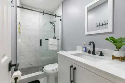 a bathroom with a shower and a toilet and a sink at Modern Miami Oasis with Pool & Water View in North Miami