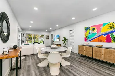 a living room with a table and a couch at Modern Miami Oasis with Pool & Water View in North Miami