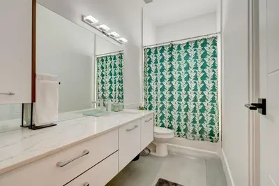 a bathroom with a toilet and a sink and a mirror at Lux Villa Sol in Miami