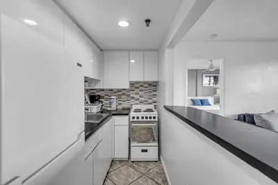 a kitchen with white cabinets and a stove top oven at 1 BLOCK FROM OCEAN 1 Bedroom in South Beach Collins Avenue in Miami Beach