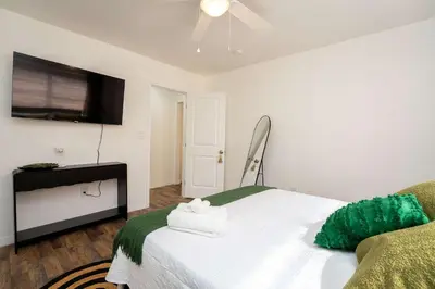 a bedroom with a bed and a flat screen tv at Family Home Casa Del Rio - Unit A in Miami