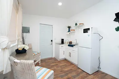a kitchen with a white refrigerator and a table at Rio retreat - Unit B in Miami