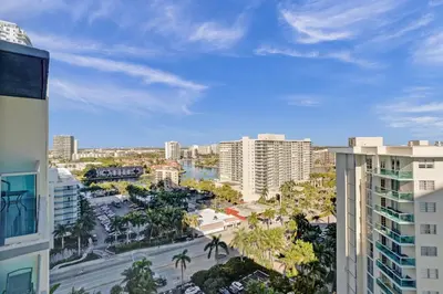 a view of a city with palm trees and buildings at Oceanview 3BR Penthouse | Pool + Beach Access in Hallandale Beach