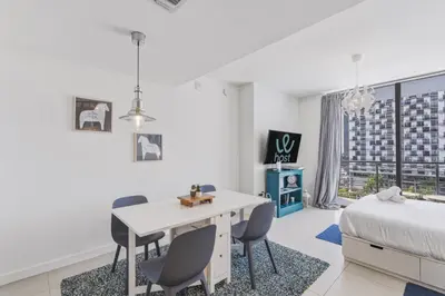 a bedroom with a bed and a table and chairs at Modern Studio in Downtown Doral in Miami