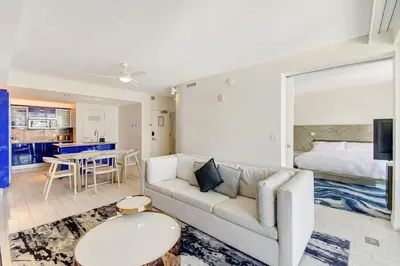 a living room with a couch and a bed at Luxe Bayview Condo w Sauna, Hot tub & Beach Access in Fort Lauderdale