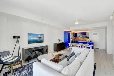 a living room with a white couch and a table at Luxe Bayview Condo w Sauna, Hot tub & Beach Access in Fort Lauderdale