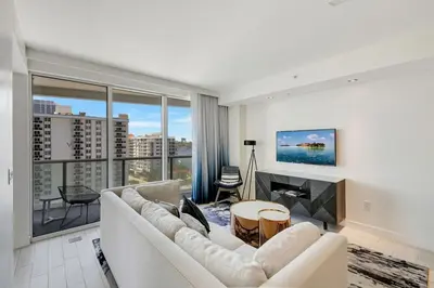 a living room with a white couch and a fireplace at Luxe Bayview Condo w Sauna, Hot tub & Beach Access in Fort Lauderdale