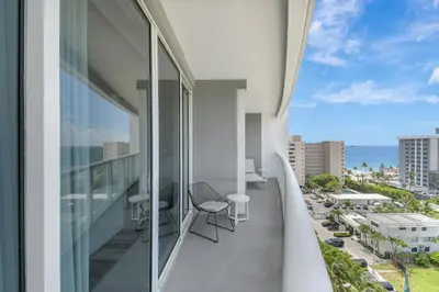 a balcony with chairs and a view of the ocean at Luxe Bayview Condo w Sauna, Hot tub & Beach Access in Fort Lauderdale