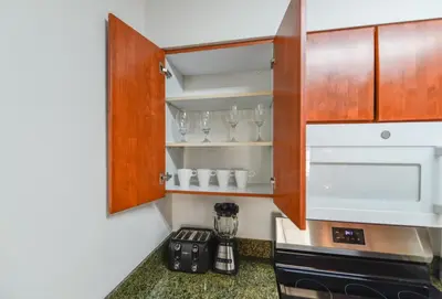 a kitchen with wooden cabinets and a blender at Luxury Suite | Sauna, Pool & Resort Access in Miami